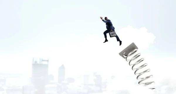 Un hombre de negocios saltando sobre un trampolín. Medios mixtos —  Fotos de Stock