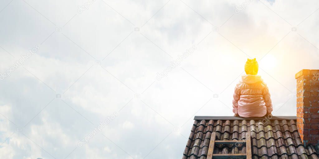 Dreamy little girl sitting alone on the roof
