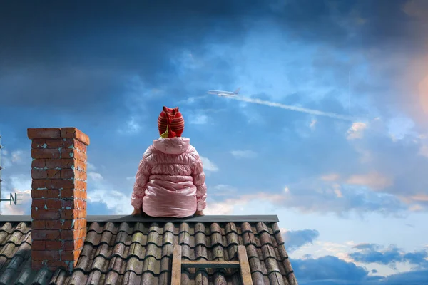 Dreamy little girl sitting alone on the roof — Stock Photo, Image