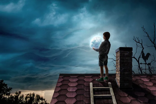 Мальчик держит луну ночью — стоковое фото