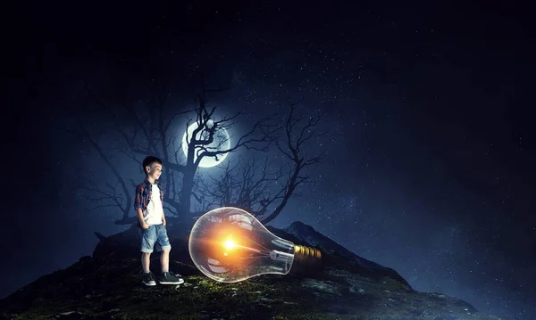 Chlapec drží žárovku — Stock fotografie