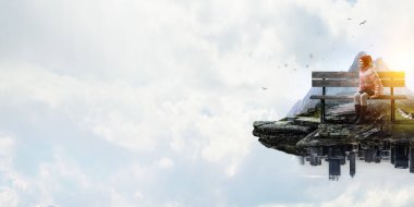 Kız oturuyor ve maceraların hayalini kuruyor.