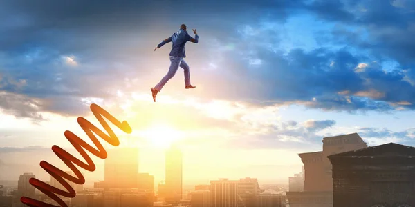 Un hombre de negocios saltando sobre un trampolín. Medios mixtos — Foto de Stock