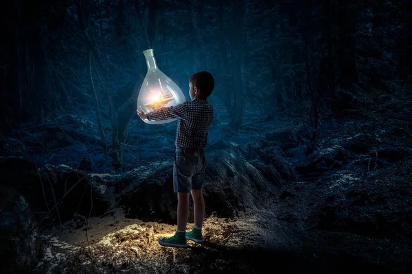 Boy holding glass flask with landscape inside it — Stock Photo, Image