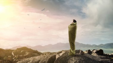 Uyku tulumundaki genç gezgin.