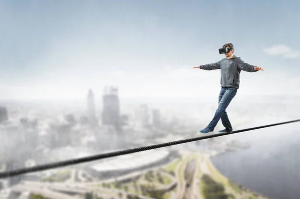 Man wearing virtual reality goggles and balancing on rope — Stock Photo, Image
