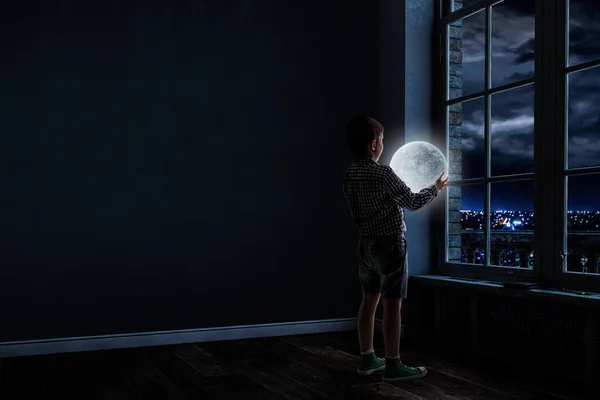 Menino segurando lua à noite — Fotografia de Stock