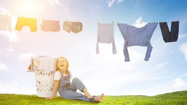 Happy little girl with washed clothes — Stock Photo, Image