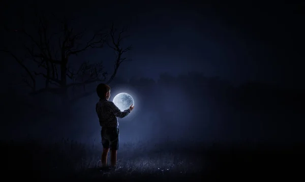Boy holding moon at night — Stock Photo, Image