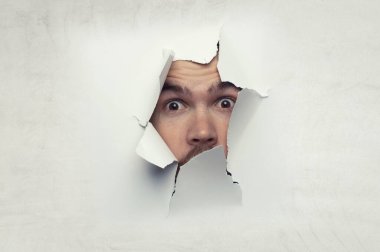 Erkek yüzü kağıttaki delikten geçiyor