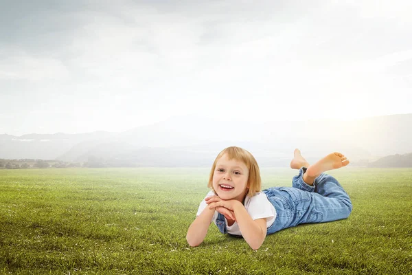 Kleines Mädchen auf dem grünen Gras — Stockfoto