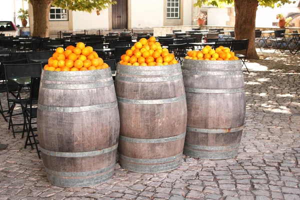Oranges in vintage wooden barrels on a medieval street in Europe