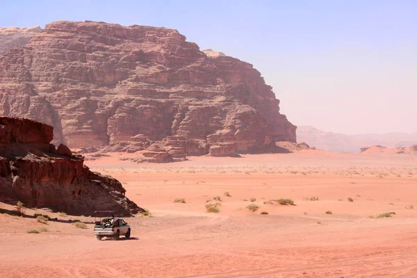 Jeep safari in Wadi Rum desert, Jordan, Middle East. Tourists in the car ride on off-road on sand among the beautiful rocks