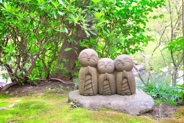 Stone statue of smiling Jizo, Kamakura, Japan Stock Photo