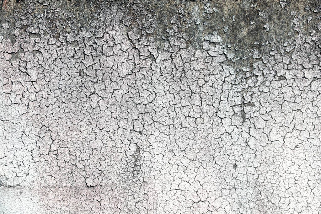 Texture of old wall with cracked stucco of white color