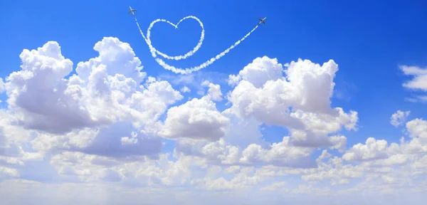 两架飞机在天空中勾画出一颗心来 飞机的飞行路线是心形的 环游世界的爱的概念 — 图库照片