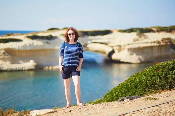 自然なアーチとイタリア サルデーニャ島の海の美しい景色を楽しむ観光女の子 — ストック写真