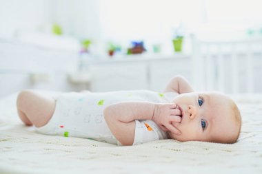 Küçük kız, yatağında yatar vaziyette anne babasının yatağına bağlı.