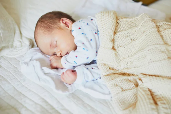 ニットブランケットの下で寝ている1ヶ月の赤ちゃんの女の子 両親のベッドで昼寝をしている子供 — ストック写真
