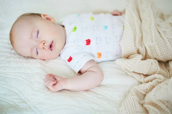 ニットの毛布の下で寝てる3ヶ月の赤ん坊の少女 両親のベッドで昼寝をしている子供 — ストック写真