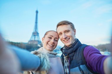 Mutlu gülümseyen çift alarak selfie Paris, Fransa'da Eyfel Kulesi ile onların hareket eden telefon ile