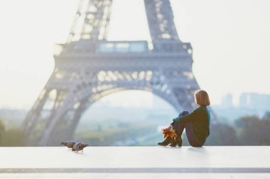 Güzel genç Fransız kadın renkli sonbahar grup ile Paris'te Eyfel Kulesinin yakınında bir sonbahar gününde bırakır