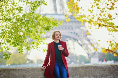 Güzel genç Fransız kadın Paris'te Eyfel Kulesinin yakınında bir Güz veya bahar gününde kahve içme