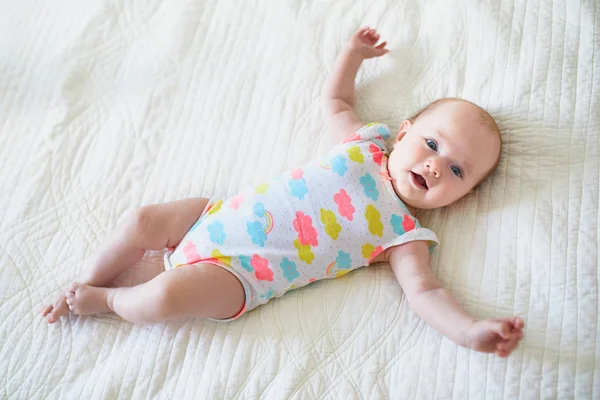 可爱的笑着的女婴躺在托儿所的床上 — 图库照片