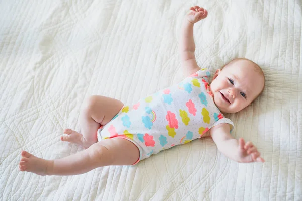 可爱的笑着的女婴躺在托儿所的床上 — 图库照片
