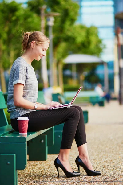 年轻漂亮的商业妇女或学生喝咖啡和工作在她的笔记本电脑户外 — 图库照片