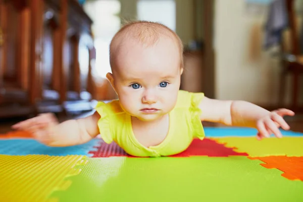 可爱的女婴在五颜六色的游戏垫子上做肚子饿 — 图库照片