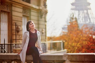 Bir parlak sonbahar gününde Eyfel Kulesinin yakınında güzel genç kadın Paris'te. Turizm ve tatil Fransa sonbahar sezon