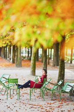 Tuileries garden Paris bir parlak sonbahar gününde güzel genç kadın. Turizm ve tatil Fransa sonbahar sezon