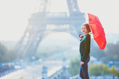 Sabah, Eyfel Kulesi yakınındaki Paris'te kırmızı şemsiye ile güzel genç kız