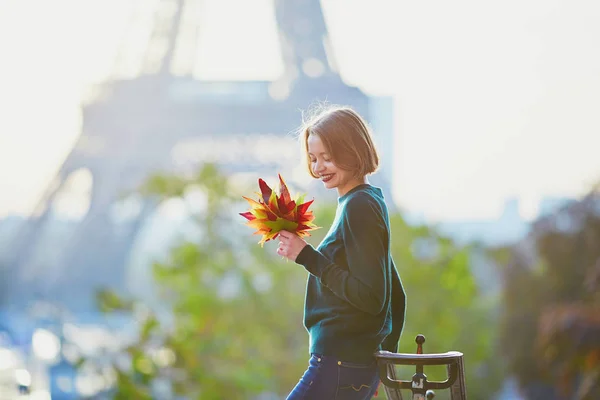 Красивая Молодая Француженка Кучей Цветных Осенних Листьев Возле Эйфелевой Башни — стоковое фото