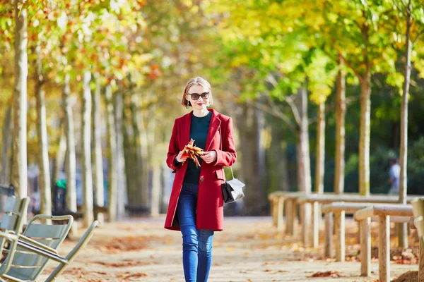 一个美丽的年轻女子带着一束五颜六色的秋叶在公园里漫步在秋季的一天 卢森堡花园 — 图库照片