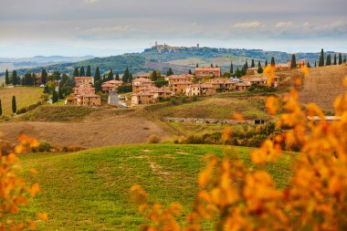 Doğal Tuscan peyzaj tepenin üst kısmında küçük bir köy ile. San Quirico d'Orcia, Toskana, İtalya