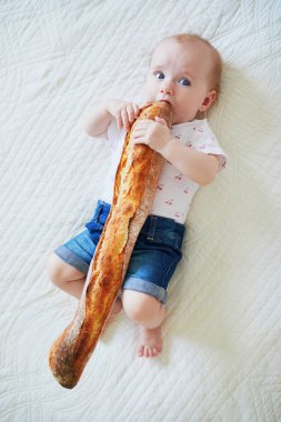 Altı aylık bebek geleneksel Fransız ekmeği (baget) yiyor. Katıları yeni doğmuş çocuklarla tanıştırmak. Sütten kesilme konsepti