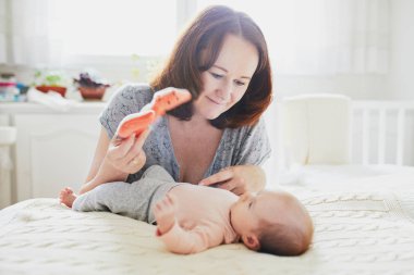 Küçük bebek kızı kapalı olan mutlu kadın. Anne ile kızı güneşli kreş