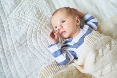 Sevimli bir kız bebek bebek odasında yatakta yatıyor.