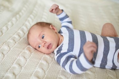 Sevimli bir kız bebek bebek odasında yatakta yatıyor.