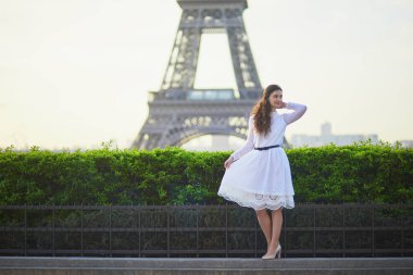 Fransa'nın Paris, Eyfel Kulesi yakınındaki beyaz elbiseli mutlu genç kadın