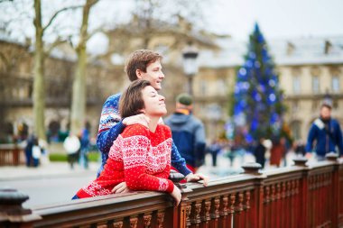 Bir sokakta renkli kazak mutlu çift Paris Noel için dekore edilmiştir.