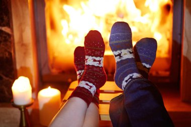 Şömine yakın sıcak çoraplı kadın ve erkek. İki ya da Noel kutlama kavramı için rahat romantik akşam