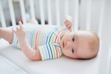 Bebek kız beşik içinde yalan. Küçük çocuk güneşli kreş