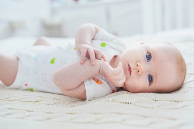 Bebek kız yatakta yatıyordu. Küçük çocuk güneşli kreş