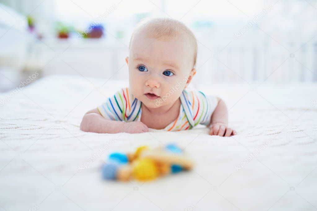 Baby girl learning to crawl. Little child doing tummy time. Infant kid in sunny nursery