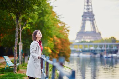 Güzel genç kadın Paris'te Eyfel Kulesi ve Seine bir parlak sonbahar gününde bakarak. Turizm ve tatil Fransa sonbahar sezon