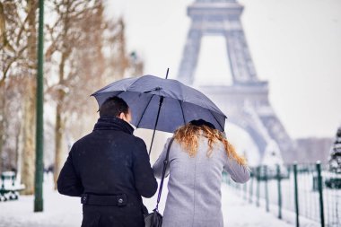 Paris'te şemsiye altında bir gün şiddetli kar yağışı ile üzerinde yürüyen turist birkaç. Olağandışı hava koşulları Paris