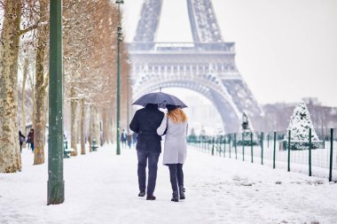 Paris'te şemsiye altında bir gün şiddetli kar yağışı ile üzerinde yürüyen turist birkaç. Olağandışı hava koşulları Paris